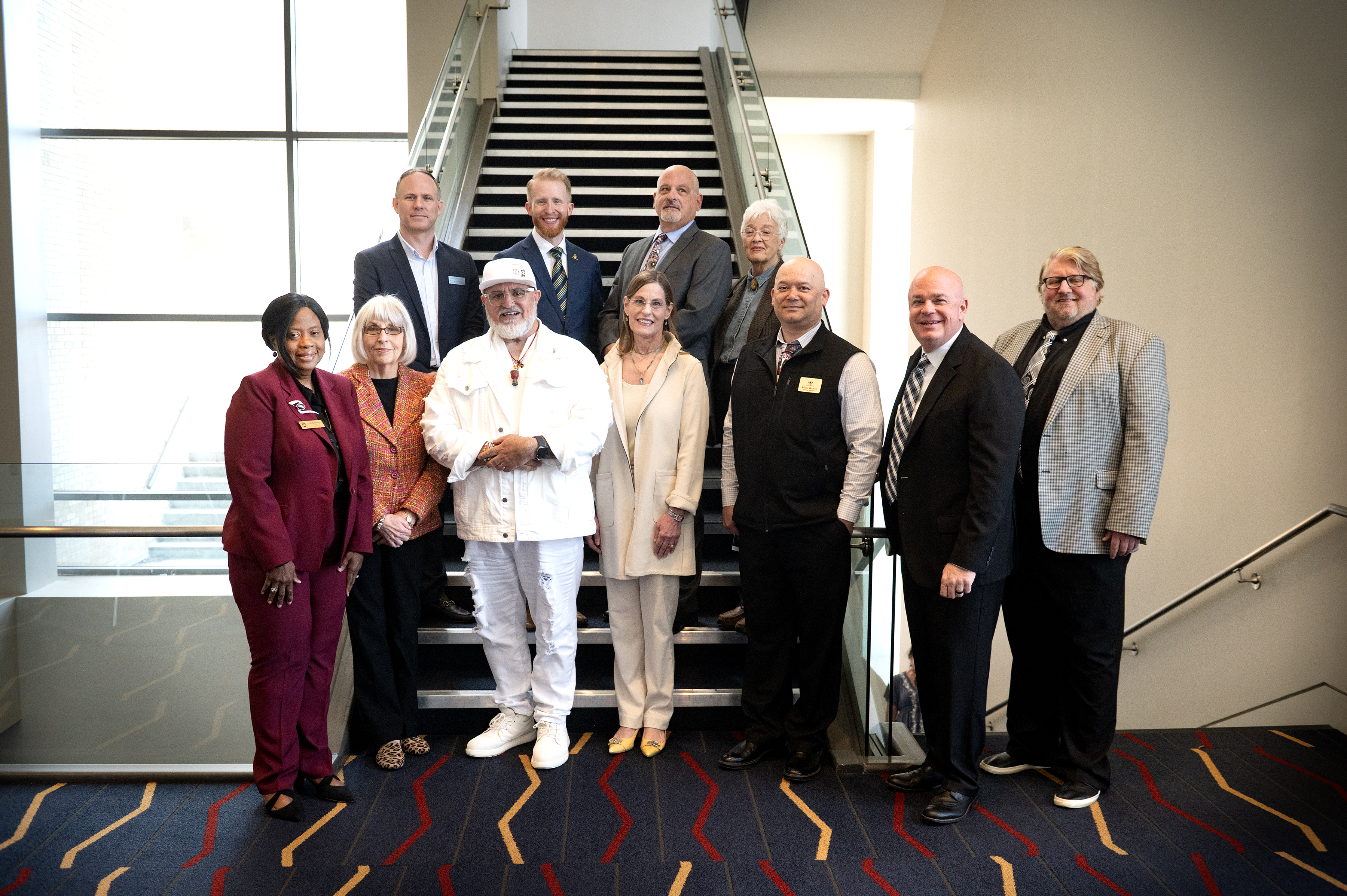 Awardees, AAC and Heritage directors stand before stairs.