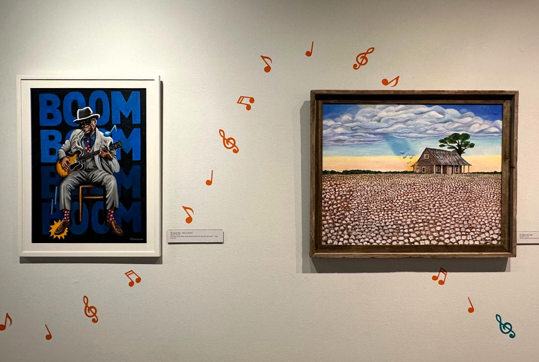 Art on a gallery wall with music note stickers floating in a line through them.