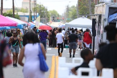 Peoplewalkingalongastreetwithmarketbooths