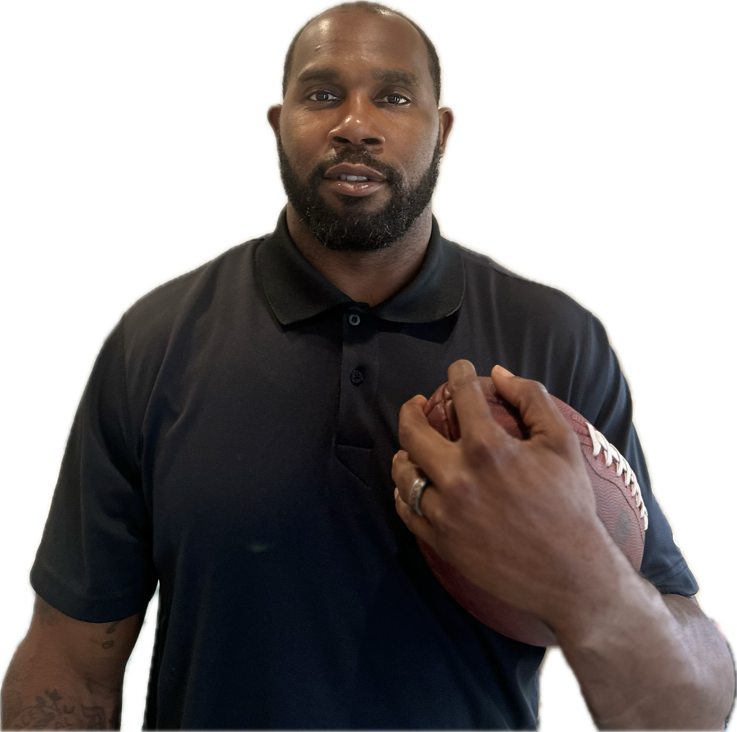 A man posing in a black shirt with a football held in his left hand.